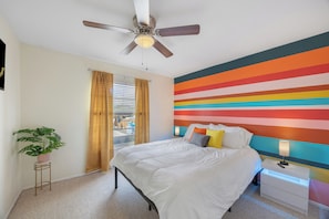 Colorful and cozy queen room with bright, cheerful energy and restful comfort.