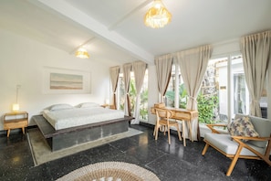 Master bedroom with queen-size bed and workspace at Villa Lalebay
