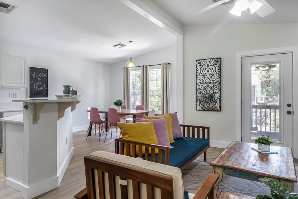 The home is spacious, open and sunlit! Kitchen, dining room an living room are all open to each other. The screened porch is just outside the door in photo.