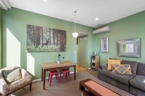 Enjoy a quiet breakfast or plan your day at the casual dining area, featuring soft lighting, woodland artwork, and seating for two.