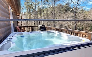 Relax in the hot tub under string lights, surrounded by forest views!