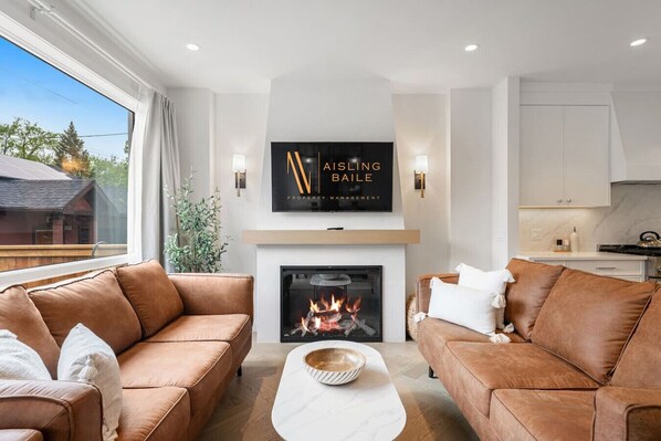 Living room with a fireplace, Smart TV, cozy seating & walkout access to the backyard.