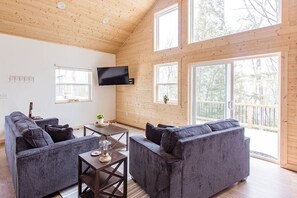 Soak in natural light from floor-to-ceiling windows in this warm and inviting living area.