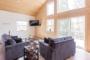 Soak in natural light from floor-to-ceiling windows in this warm and inviting living area.