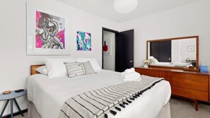 King bedroom with fresh linens and workspace 