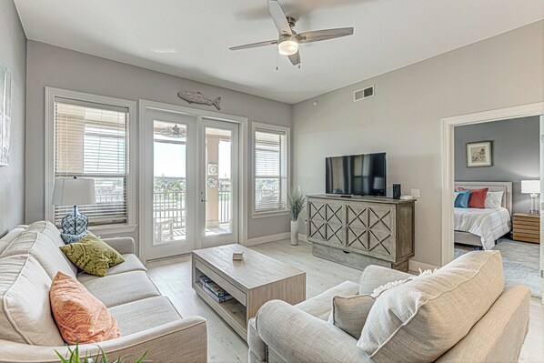 Living area with ample seating, Smart TV, and balcony 