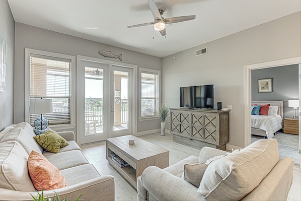 Living area with ample seating, Smart TV, and balcony