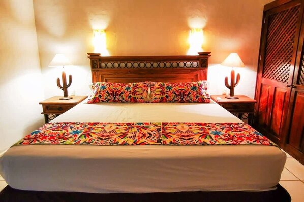 Master bedroom with a king bed, Smart TV, Soft bedside lighting, direct access to bathroom, view of the gardens.