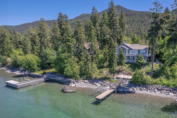 Set among towering trees with 100 feet of private lake frontage, you’ll enjoy direct access to Flathead Lake from your private dock and boat lift (pontoon compatible), making it the ideal base for boating, swimming, or just soaking up the sun.