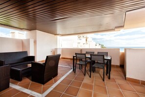 Large south-facing terrace with outdoor seating and dining area for four guests