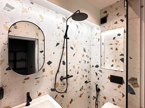 Enjoy a spa-like shower with rainfall head and chic terrazzo tiles. Curious about our toiletries? We’ve got you covered!