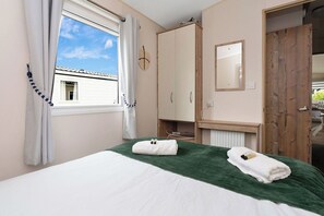 Bright and cozy bedroom with a comfortable bed, fresh linens, and convenient storage—ideal for a relaxing stay.