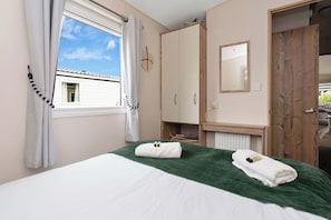 Bright and cozy bedroom with a comfortable bed, fresh linens, and convenient storage—ideal for a relaxing stay.