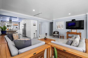 Spacious, sunlit living area with plush seating, 85” Smart TV, and easy backyard access—perfect for unwinding in style.