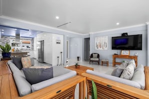 Spacious, sunlit living area with plush seating, 85” Smart TV, and easy backyard access—perfect for unwinding in style.