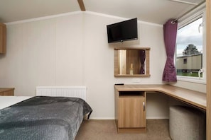 Enjoy your own peaceful corner with a comfy bed, smart TV, and a bright workspace by the window—perfect for both relaxing and unwinding.