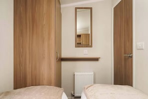 Unwind in this cozy twin room featuring plush bedding, a spacious wardrobe, and a stylish vanity—perfect for a restful and refreshing retreat.