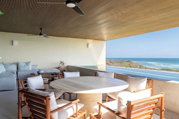 Terraza con comedor exterior y vista al mar