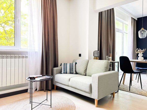 Unwind in this bright, stylish living space — perfect for lounging or planning your day. Curious about Smart TV options? Just ask!