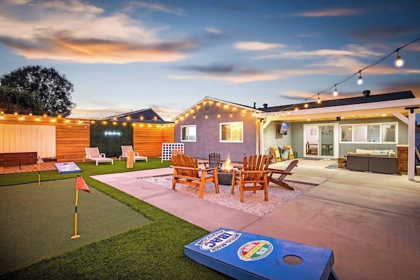 Relax and unwind in our renowned backyard oasis, featuring a variety of fun games, a cozy fire pit, a soothing hot tub, and a covered patio perfect for any gathering