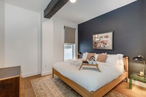 Primary bedroom with a King bed, stylish accent wall, and convenient closet space.