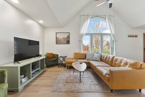 Large open living room that has ample seating on a large mid century modern sectional.