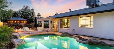 Twilight view of the pool and patio with stunning architecture.