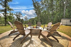 Cozy fire pit area with Adirondack chairs—gather under the stars, roast marshmallows, and share stories in your private Ellijay cabin rental retreat