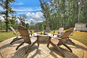 Cozy fire pit area with Adirondack chairs—gather under the stars, roast marshmallows, and share stories in your private Ellijay cabin rental retreat