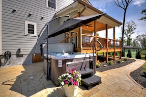 Backyard hot tub nestled among the trees with a large overhanging umbrella for shade—relax in comfort and privacy after a day exploring Ellijay’s hiking trails or apple farms. A perfect addition to this pet-friendly North Georgia Mountain cabin rental