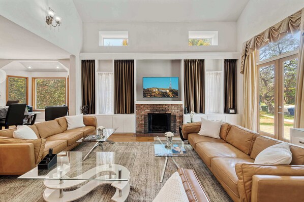 Step into Style - Soaring ceilings and sunlight welcome you to a living room made for lounging, laughing, and a little showing off.