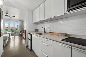 Sleek, compact kitchen leading to a bright, spacious studio with stunning views.