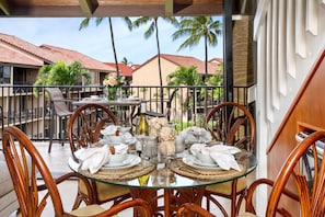 PKC-403 This inviting balcony dining area features rattan chairs, tropical blooms, and a tranquil Hawaiian courtyard view