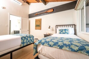 NAP-C43 Stylish guest room with twin beds, vaulted ceilings, tropical prints, and bright views of lush garden greenery
