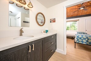 NAP-C43 A sleek vanity with dark wood cabinetry and matte bronze fixtures brings warmth and contrast to this serene master bath