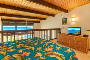 NAP-C42 Lofted master suite with rich wood ceilings, tropical bedding, natural light, and serene views from wide windows