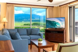 HKH-520 Spacious, sun-filled living room with panoramic floor-to-ceiling views of Maui's lush landscapes and ocean horizon
