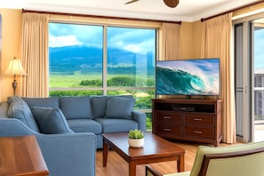 HKH-520 Spacious, sun-filled living room with panoramic floor-to-ceiling views of Maui's lush landscapes and ocean horizon
