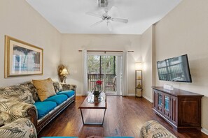 Bright and comfy living room with TV and easy patio access.