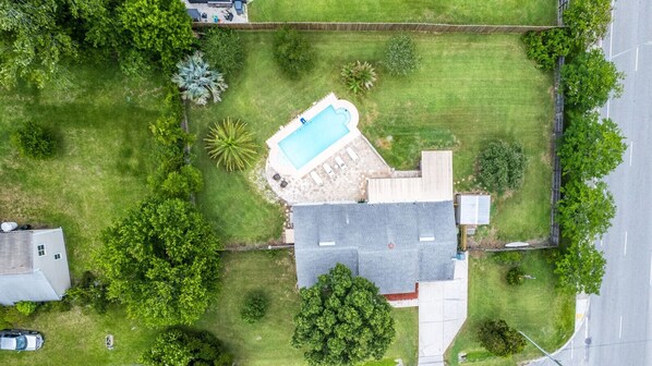 Spread out and unwind in this fully fenced half-acre yard — poolside lounging, shaded seating, and a perfect setup for outdoor entertainment.
