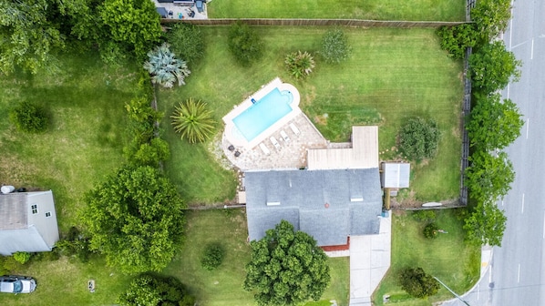 Spread out and unwind in this fully fenced half-acre yard — poolside lounging, shaded seating, and a perfect setup for outdoor entertainment.