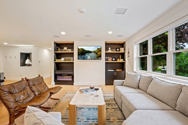 A bright and welcoming living room with large windows and stylish furnishings.