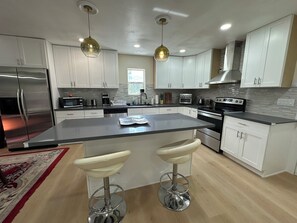Open kitchen, island with coffee machine, oven, and dish washer