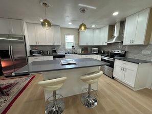 Open kitchen, island with coffee machine, oven, and dish washer