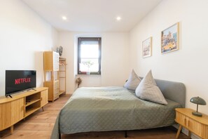 Das Schlafzimmer verfügt über einen offenen Kleiderschrank und eine Kommode.