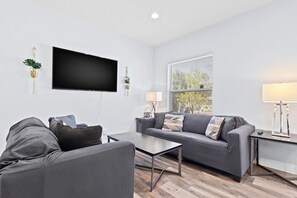 Relax in a bright, spacious living area equipped with smart TV and modern decor – perfect for unwinding after exploring Tampa.