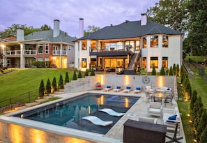 Every detail of this backyard retreat screams luxury—from the sunken loungers to the poolside bar and tiered landscaping.