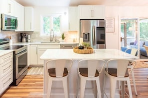 Sleek modern kitchen with smart fridge and countertop seating at the island bar. This is the heart of the home!