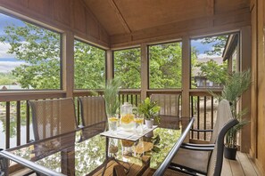 Unwind on the covered deck with outdoor dining tables and chairs, enjoying fresh air and peaceful surroundings in this home near Silver Dollar City. The perfect spot for al fresco meals or simply taking in the serene atmosphere with family and friends.