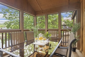 Unwind on the covered deck with outdoor dining tables and chairs, enjoying fresh air and peaceful surroundings in this home near Silver Dollar City. The perfect spot for al fresco meals or simply taking in the serene atmosphere with family and friends.